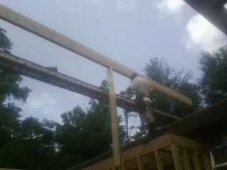 Carpenter setting a ridge beam over a new addition frame — Ice Dam Removal by Roofing Brothers in Moorestown