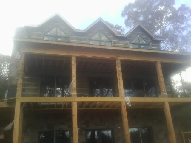 Dormers and porch framing on a large log home under construction — Roof Coating work by our crew in Moorestown