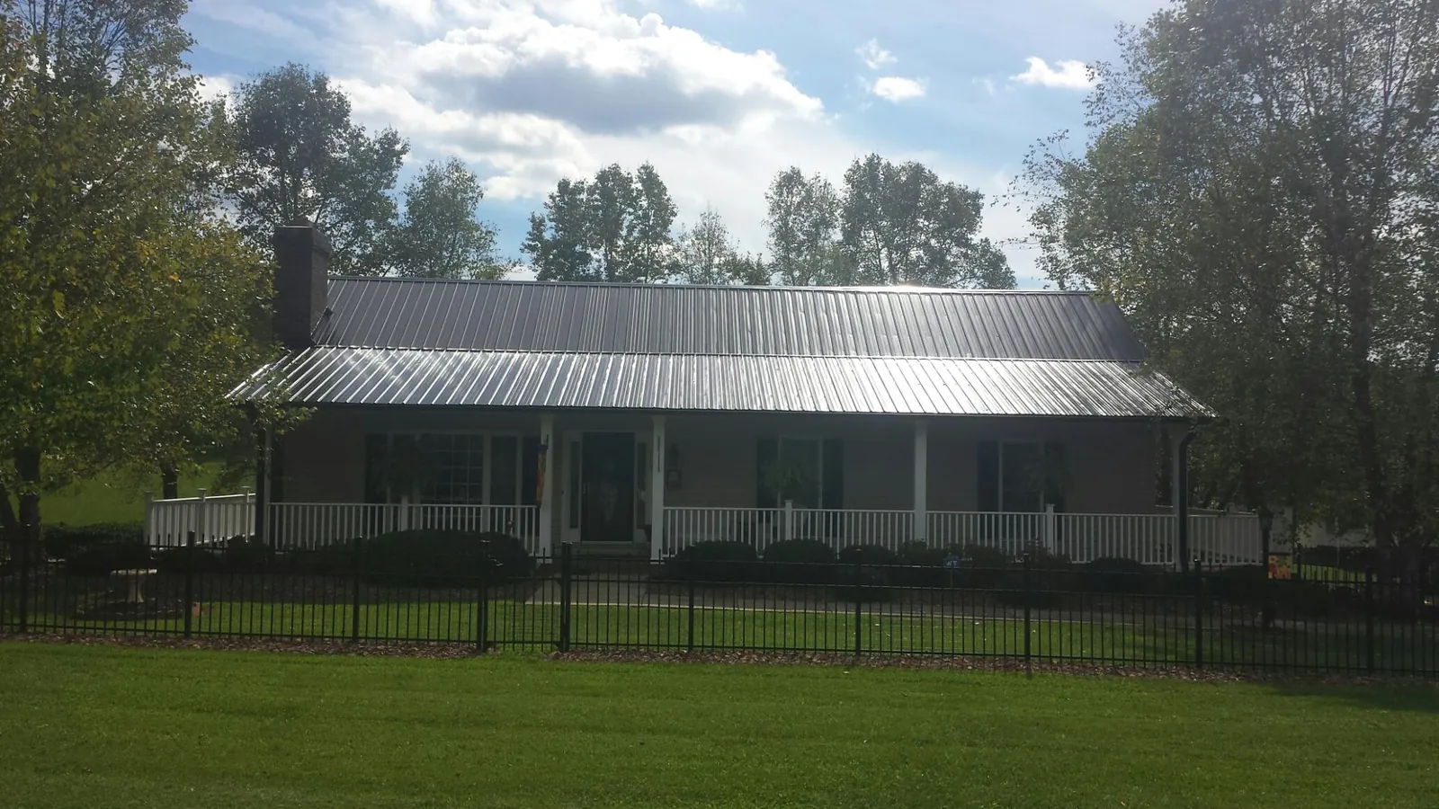 Gray metal roof on a brick ranch with a full width front porch — Gutter Guard Installation work by our crew in Moorestown