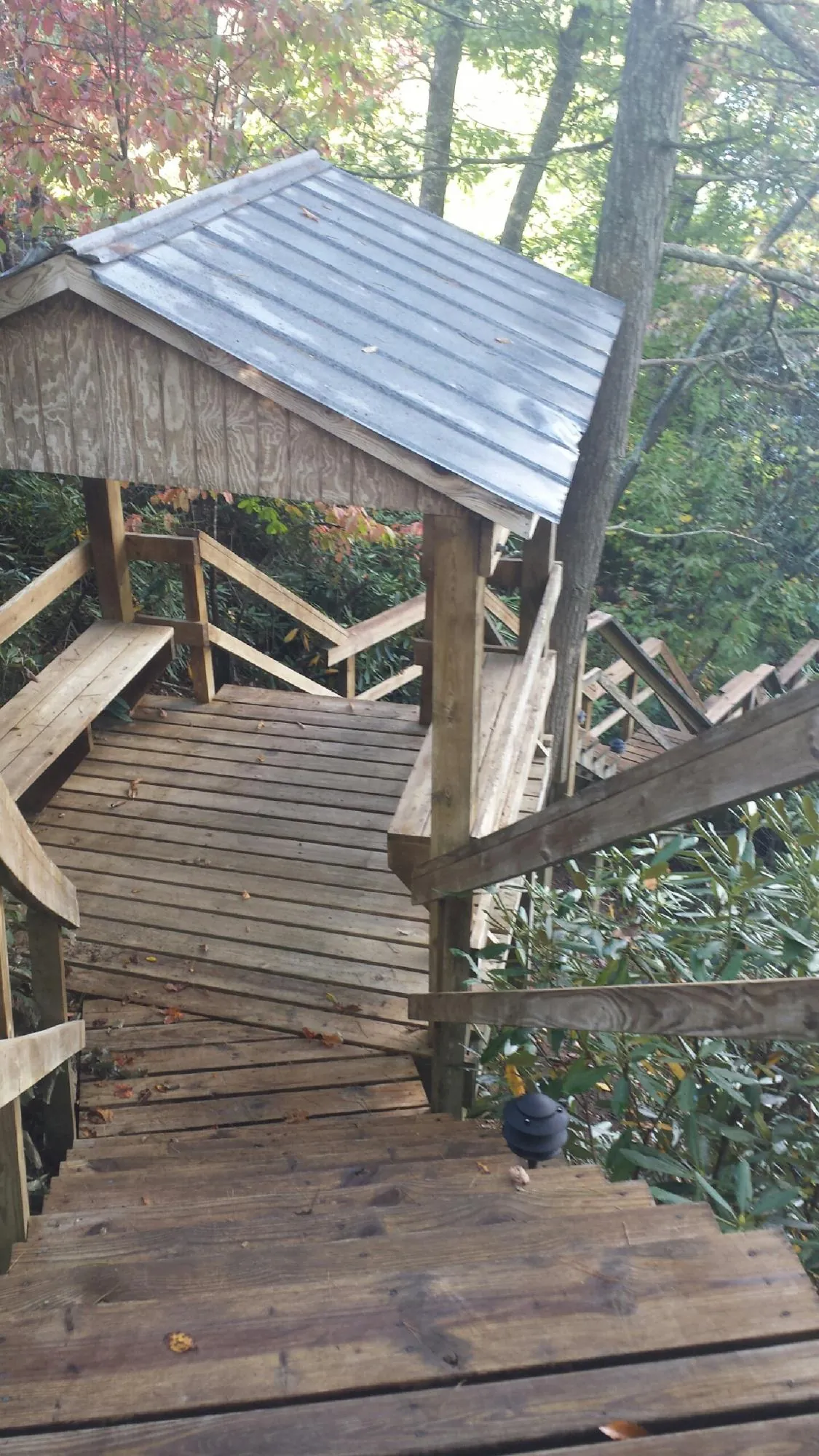 Metal roofed shelter over wooden steps on a wooded walkway — Skylight Repair & Installation work by our crew in Moorestown