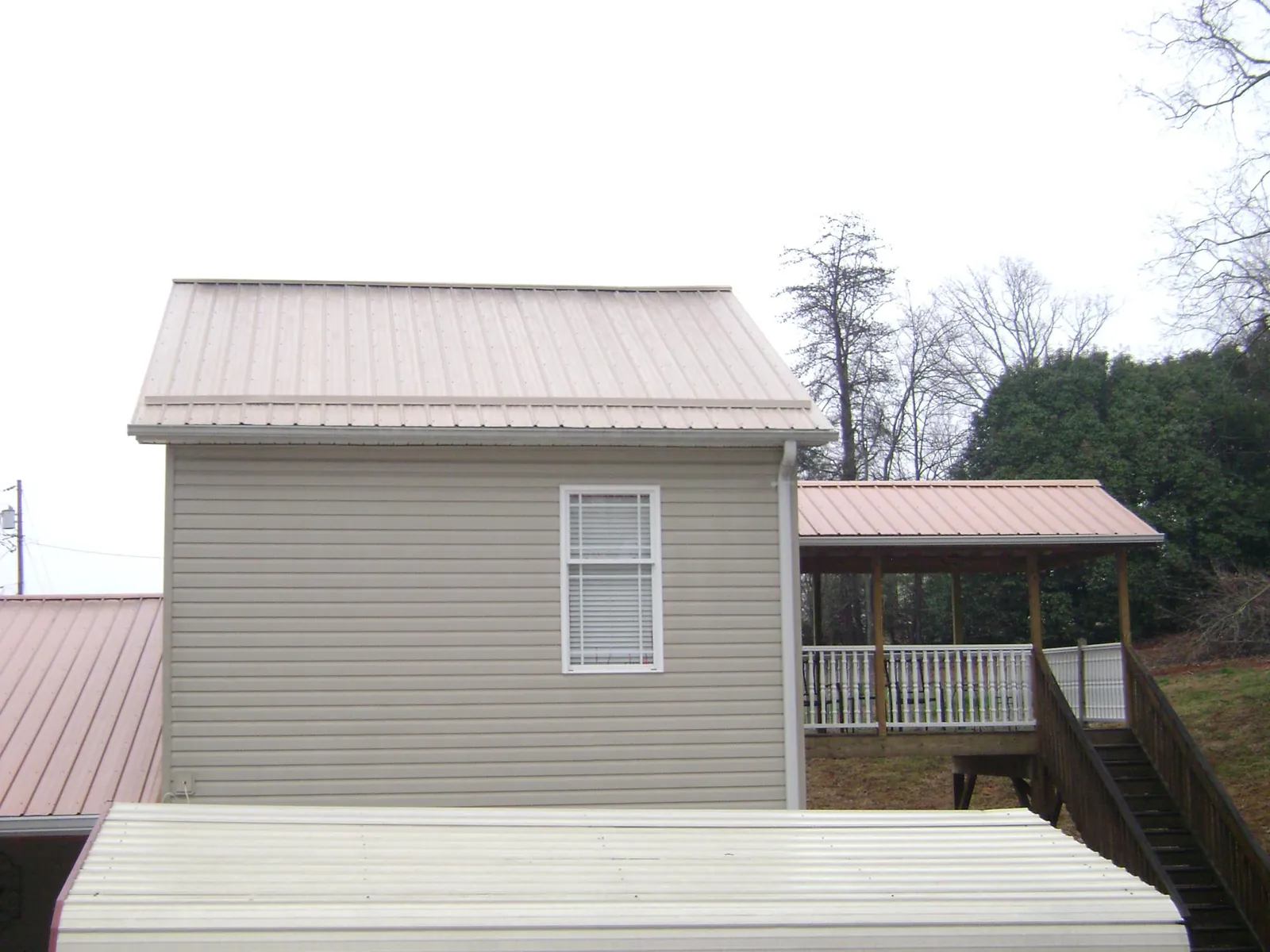 Tan metal roofs on a two story addition and attached porch, from a Roof Replacement job in Moorestown
